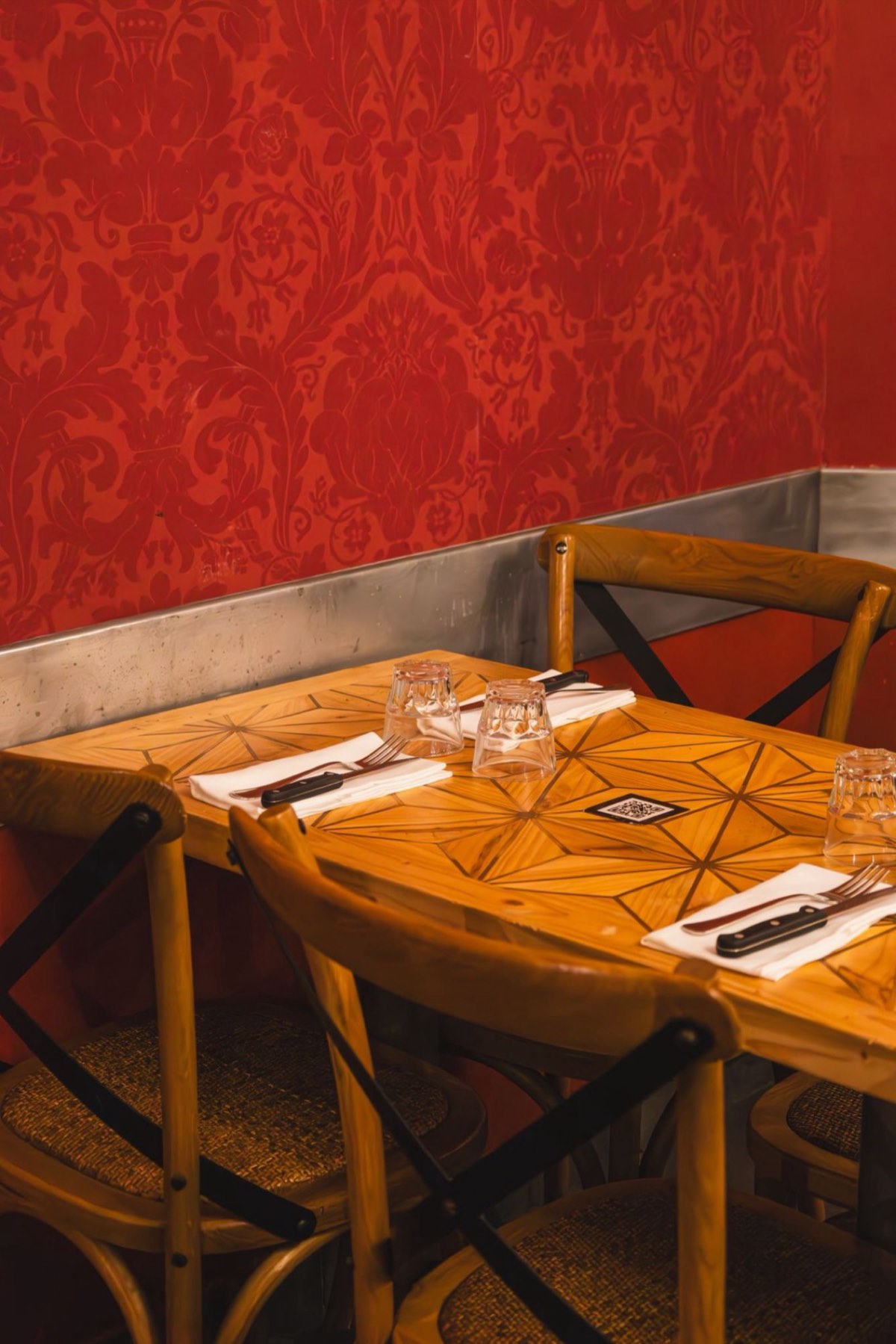 Le papier peint damassé rouge au-dessus des banquettes