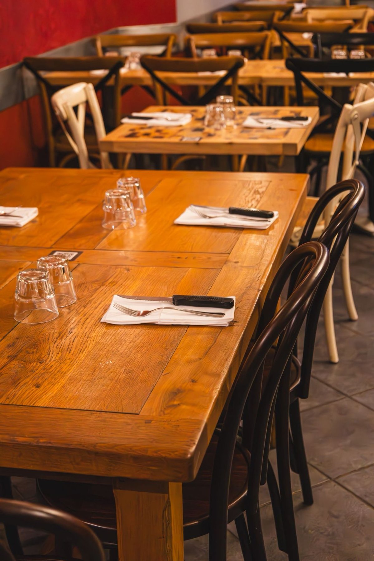 Les tables de bois clair et les chaises bistrot, dressées avant le service